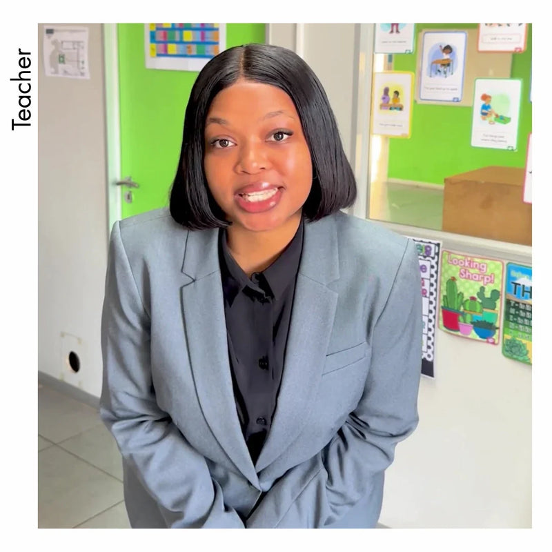 Professional teacher in a grey blazer and black shirt, styled in women's office wear.