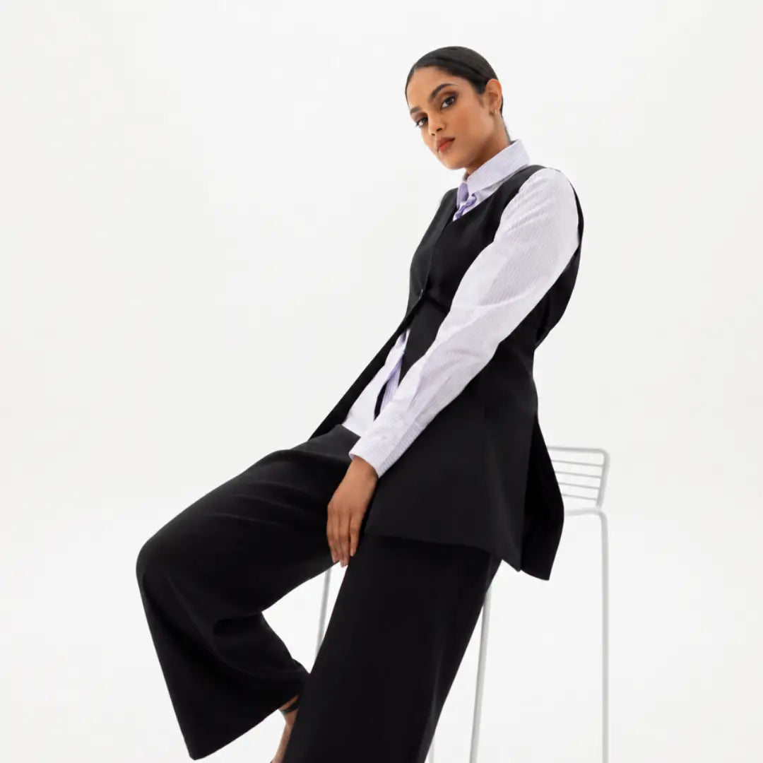 Women wearing a striped shirt and black waistcoat and black pants by ImNow.