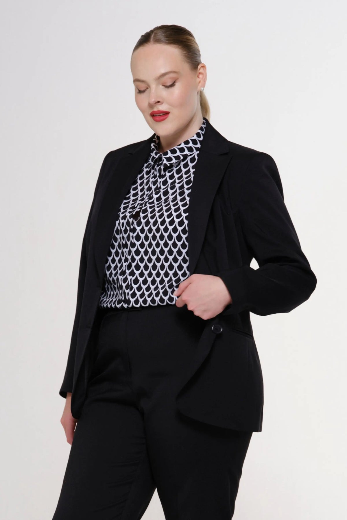 Black women’s tailored blazer and trousers set with patterned high-neck blouse
